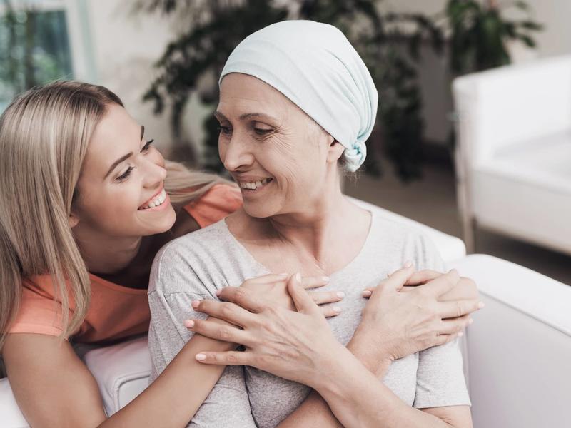 Two women smile and hug