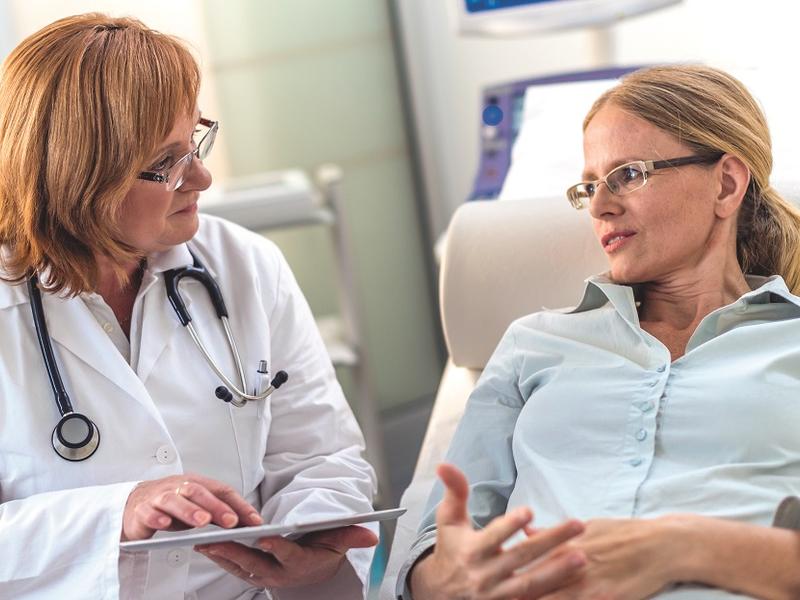 Doctor speaking with patient in chair