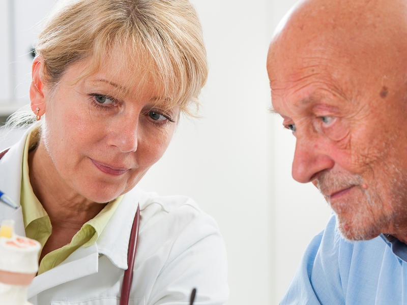 Clinical care provider speaking with seated patient